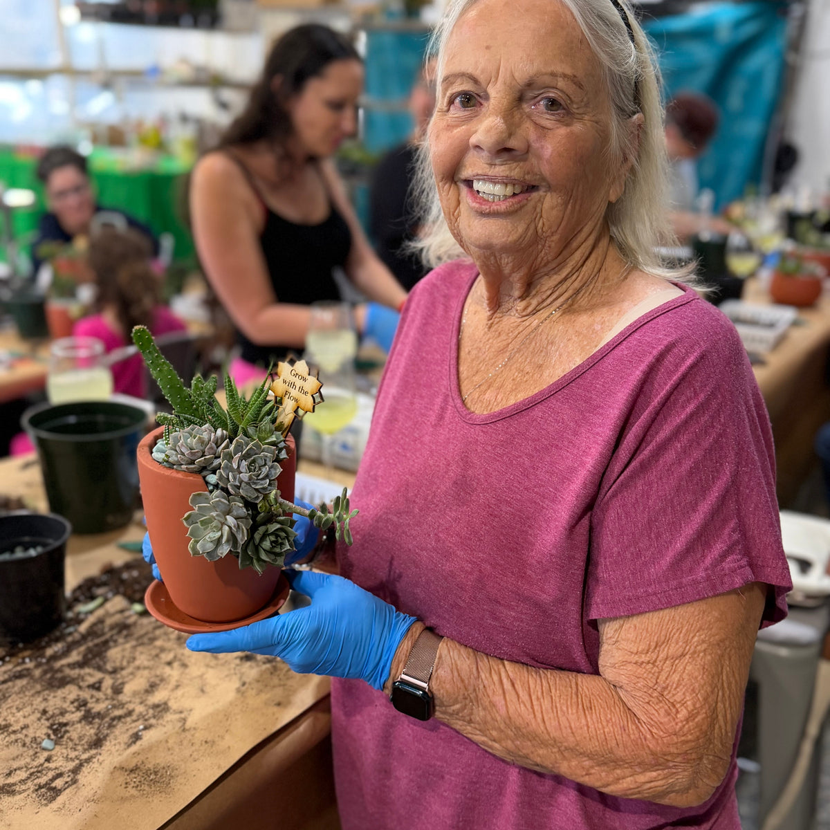 Woman holding a potted plant in a workshop setting