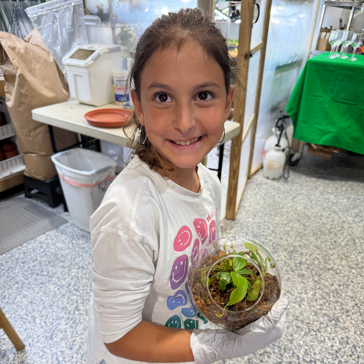Child holding a terrarium in a workshop setting